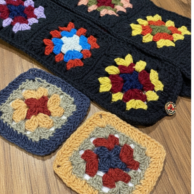 A selection of crochet granny squares lying flat on a table. 