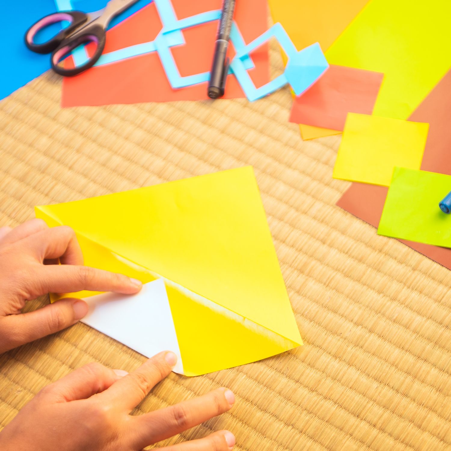 Image of a child folding paper for origami