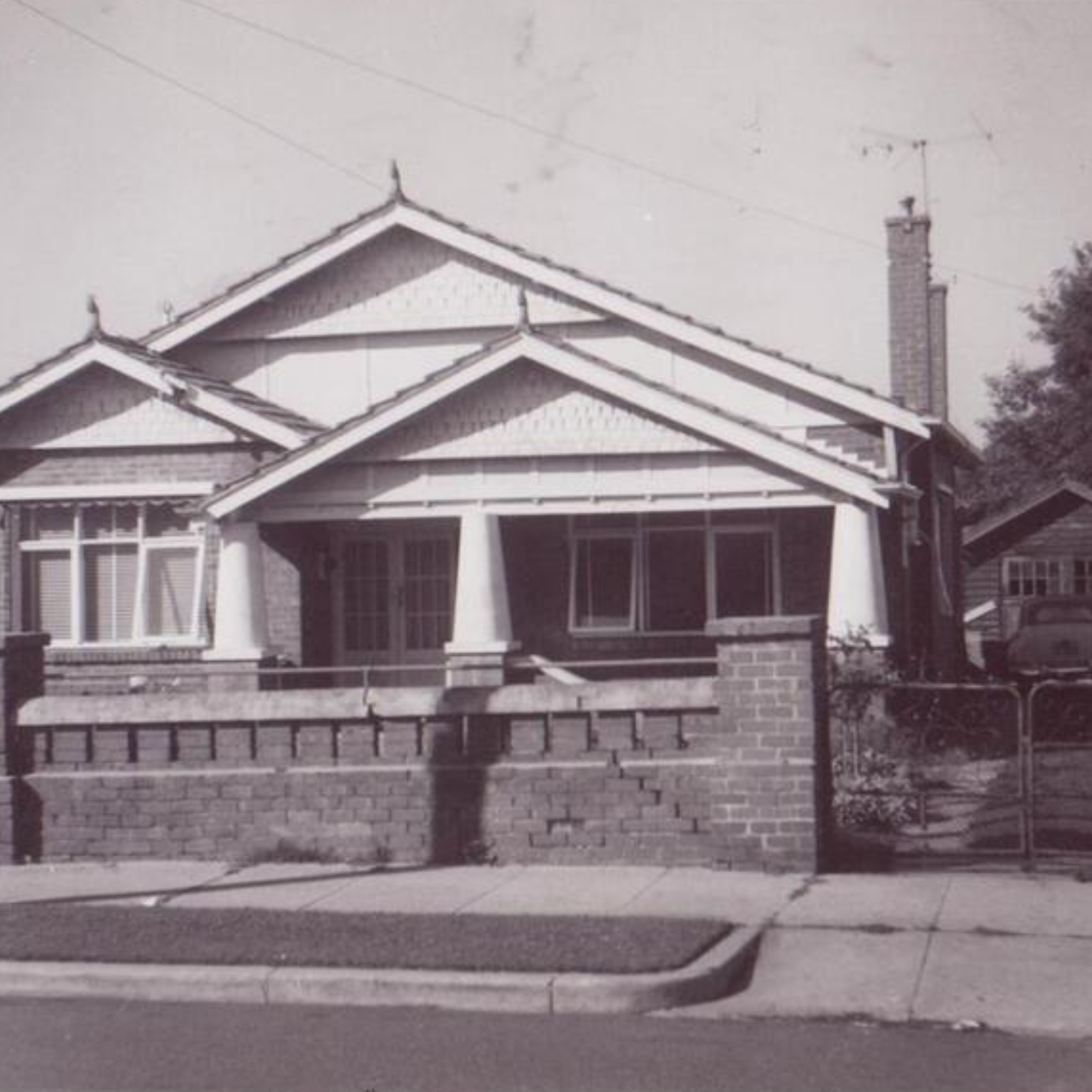 A sepia image of a suburban house. It is a California bungalow style house