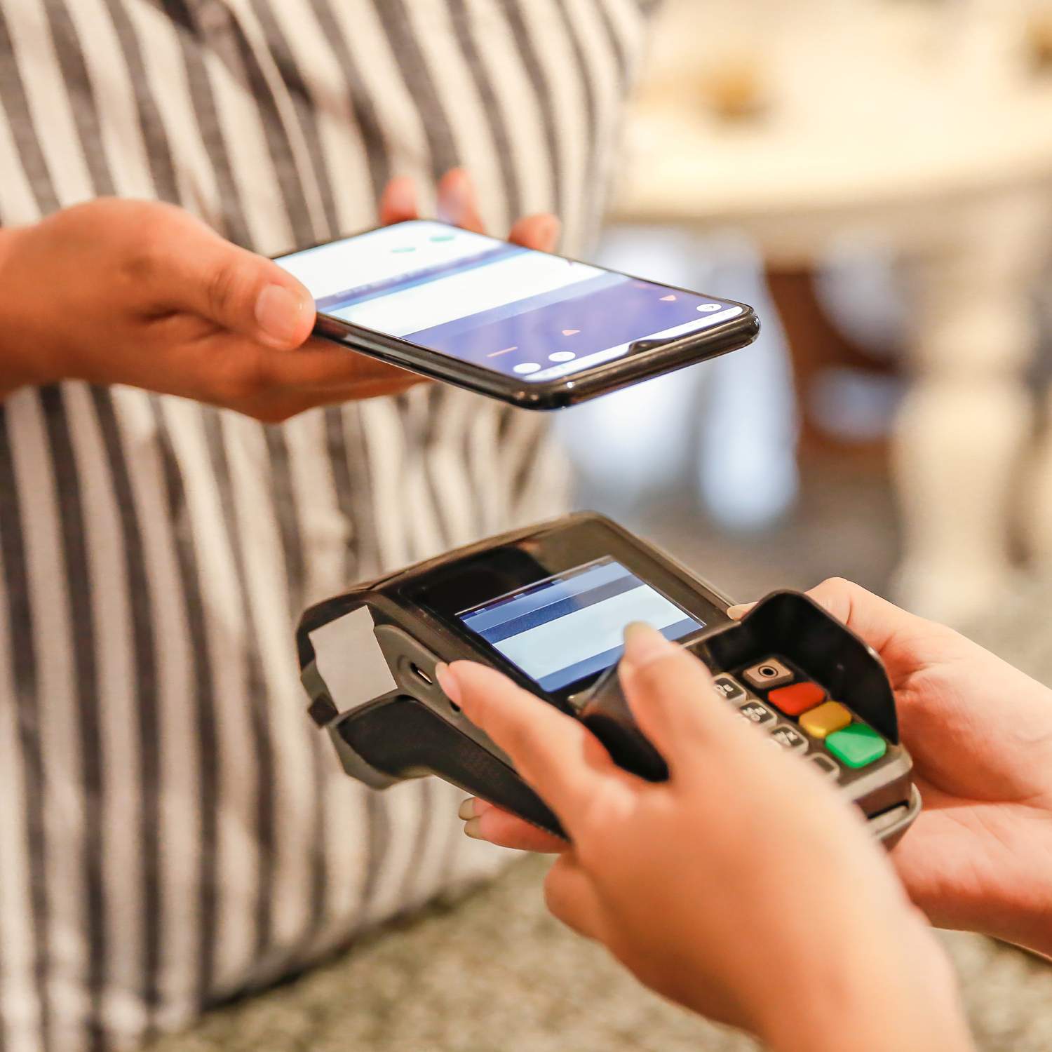 Image of a mobile phone hovering over a eftpos terminal