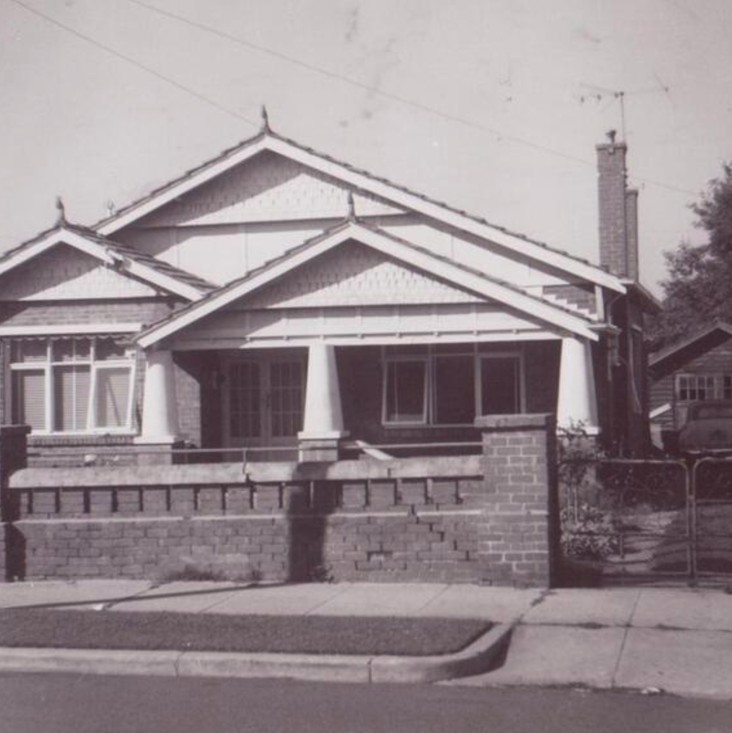 A sepia image of a suburban house. It is a California bungalow style house