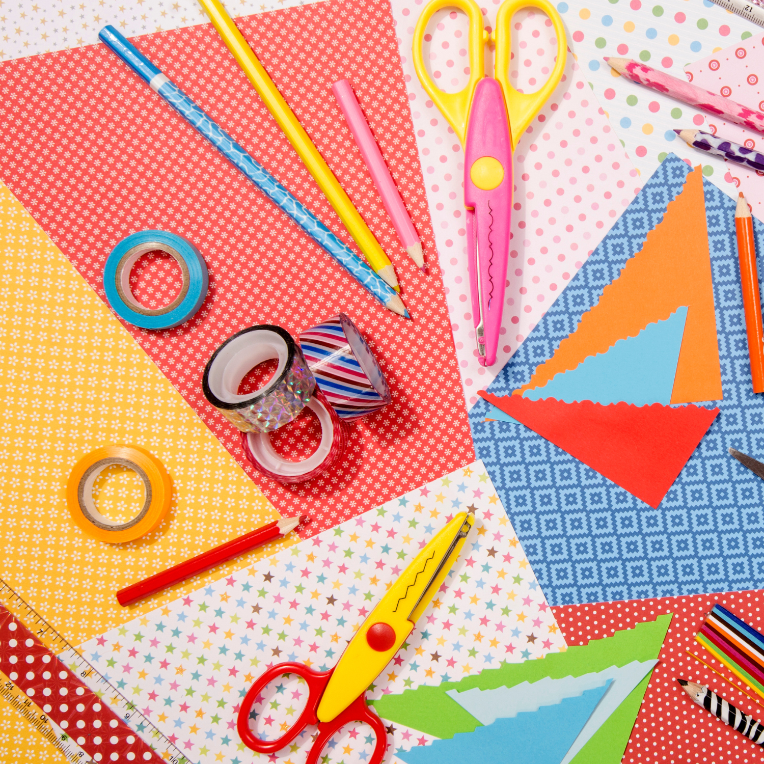 Craft supplies laid out on a table including stencils, textas and scissors
