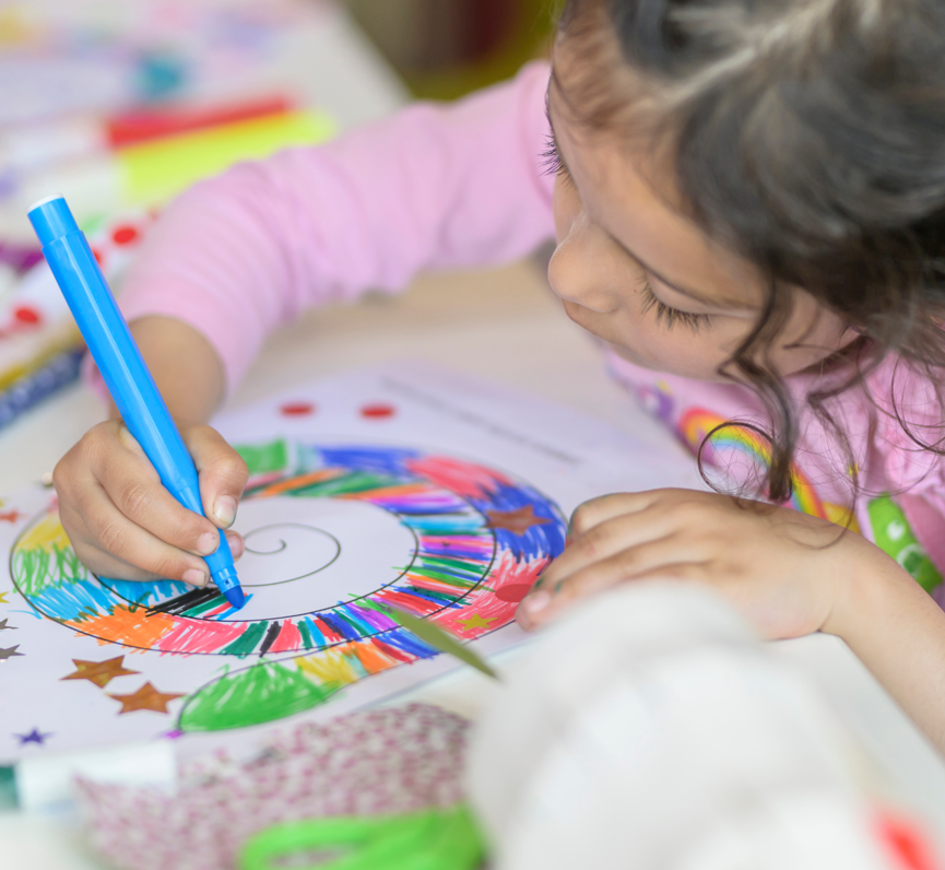 Image of a young girl colouring in a snake on paper
